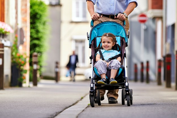 Isaure, a vaccine patient in Belgium sitting in a baby-seat car