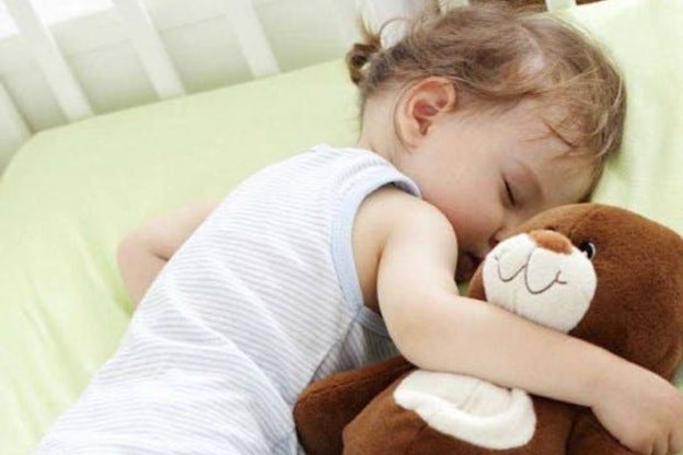 Vediamo una bimba abbracciare nel sonno un orsacchiotto