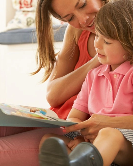 Una mamma abbraccia la figlia mentre leggono insieme