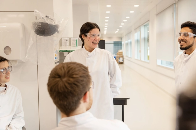 Vediamo degli scienziati al lavoro in un laboratorio.
