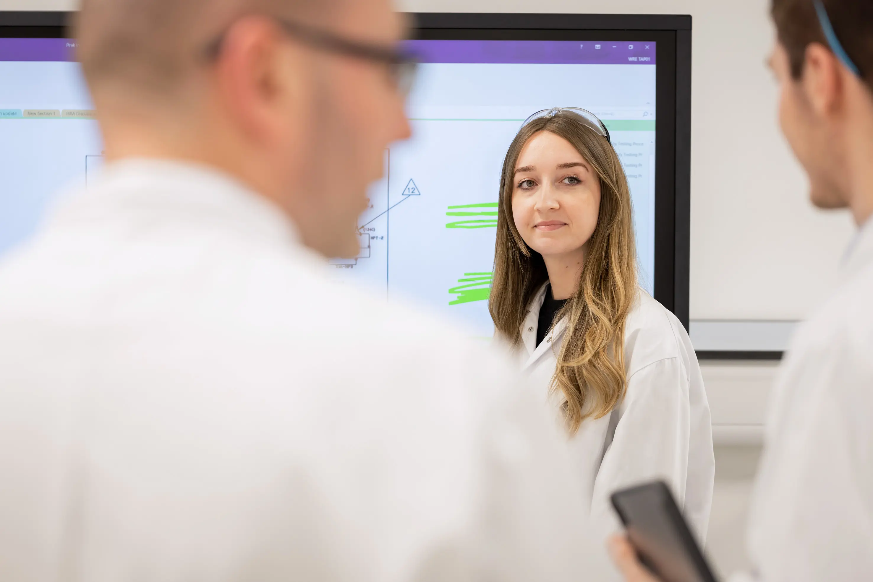 Vediamo una ricercatrice davanti ad una lavagna luminosa.