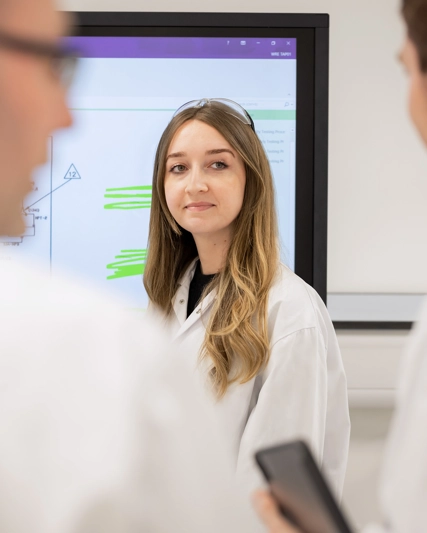 Vediamo una ricercatrice davanti ad una lavagna luminosa.